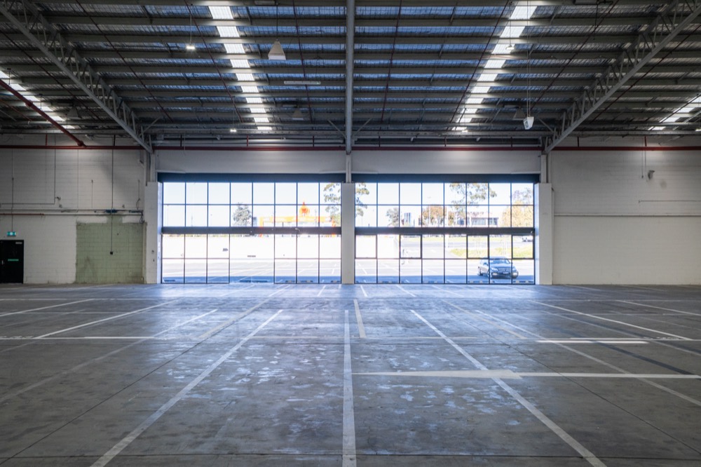 Inside the M7 Warehouse, a large open industrial event space with a glazed roller door